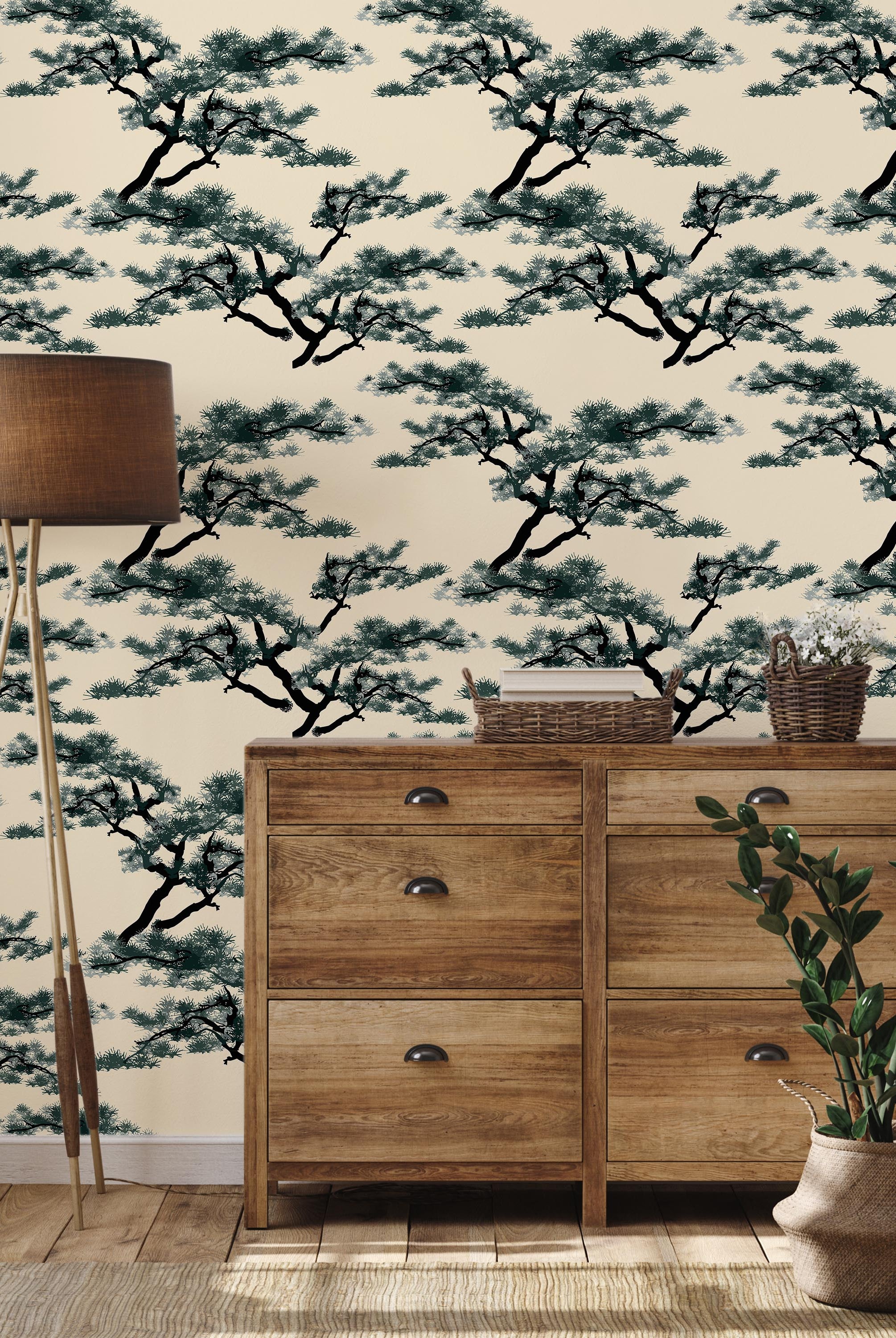 a wooden dresser with drawers, a floor lamp, and a potted plant, all set against a wall with a repeating pattern of pine tree silhouettes.