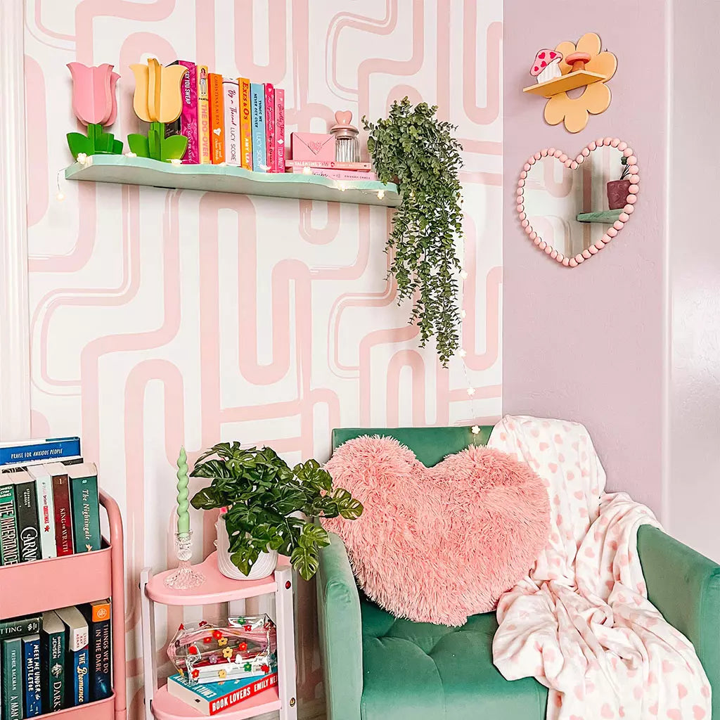 Children's room with pink wall, green sofa, and decorative elements.